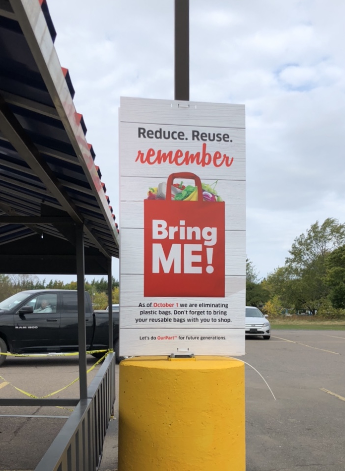 Panneau « Reduce Reuse Remember » dans un stationnement de Foodland