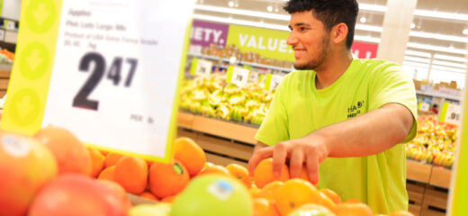 Un employé de Chalo FreshCo stocke des fruits frais en magasin.