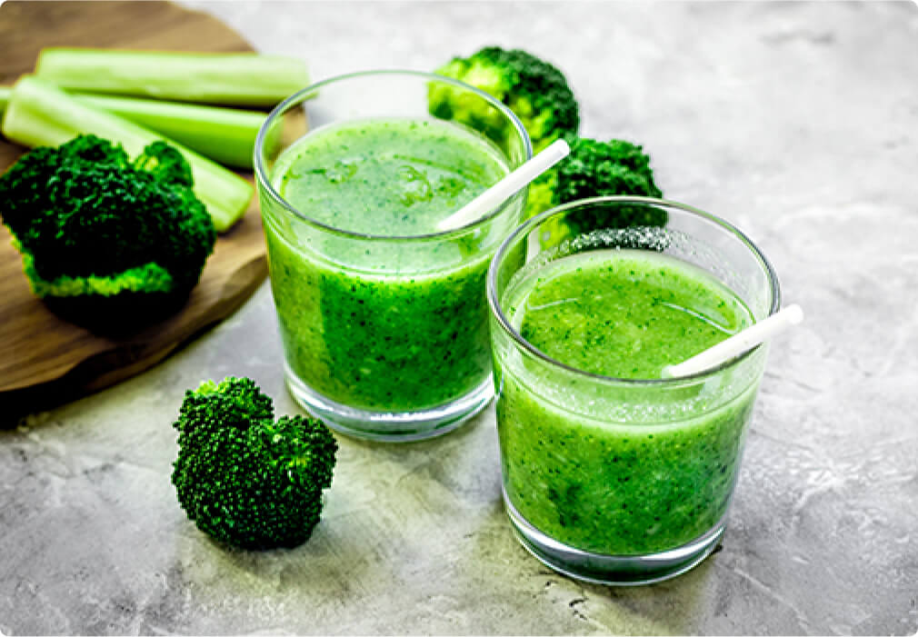 Two glasses filled with broccoli stem smoothie